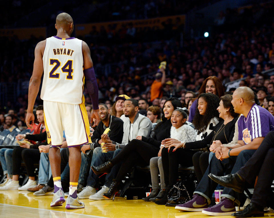 Kobe Bryant of the Los Angeles Lakers speaks with his daughters Gianna, 8, Natalia, 12, and wife Vanessa during the basketball game against the Indiana Pacersin Los Angeles, on Nov. 29, 2015 | Kevork Djanzesian—Getty Images