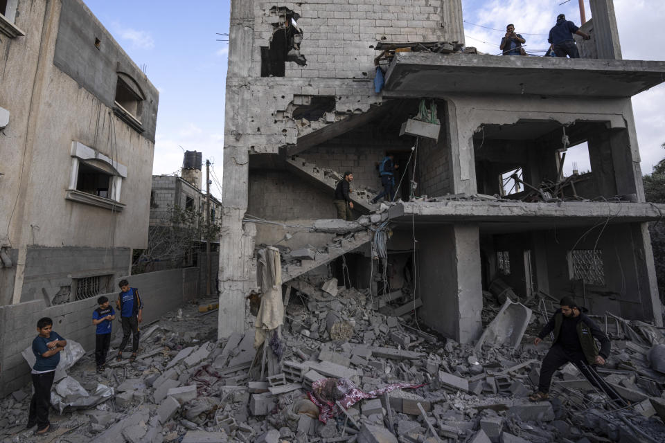 Palestinians inspect the rubble at the site of an airstrike that the Israeli military said targeted the house of an Islamic Jihad member, in Deir al-Balah, central Gaza Strip, Saturday, May 13, 2023. (AP Photo/Fatima Shbair)