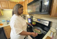 In this May 2021 image taken by Crystal Jackson, Lori Jackson cooks a steak and asparagus recipe she found from TikTok at her home in Lynn, Mass. Since the pandemic, TikTok has become a place for people to find new recipe ideas as well as burgeoning celebrity chefs. (Crystal Jackson via AP)