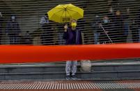 A pro-democracy supporter shouts slogans behind a police cordon line as she queues up for hearing outside a court in Hong Kong, Thursday, March 4, 2021. A marathon court hearing for 47 pro-democracy activists in Hong Kong charged with conspiracy to commit subversion enters its fourth day on Thursday, as the court deliberates over whether the defendants will be granted bail. (AP Photo/Vincent Yu)