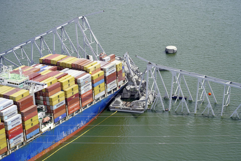 In this aerial image released by the Maryland National Guard, the cargo ship Dali is stuck under part of the structure of the Francis Scott Key Bridge after the ship hit the bridge, Tuesday, March 26, 2024, in Baltimore. (Maryland National Guard via AP)