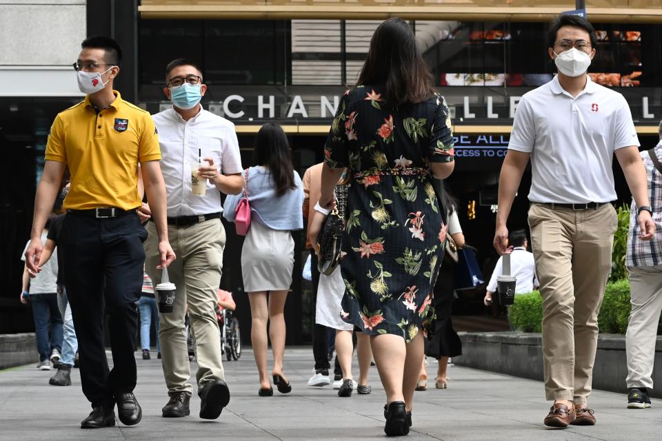 People walk during their lunch break in the financial business district of Raffles Place in Singapore on January 11, 2021. (Photo by Roslan RAHMAN / AFP) (Photo by ROSLAN RAHMAN/AFP via Getty Images)