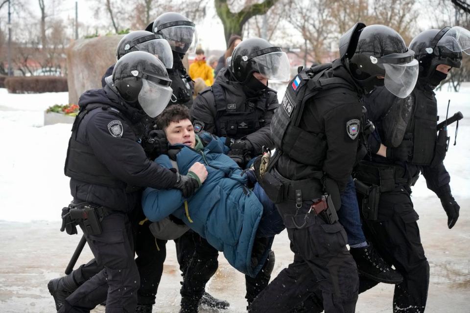 Police detain a man paying his last respects to Navalny in St Petersburg (AP)