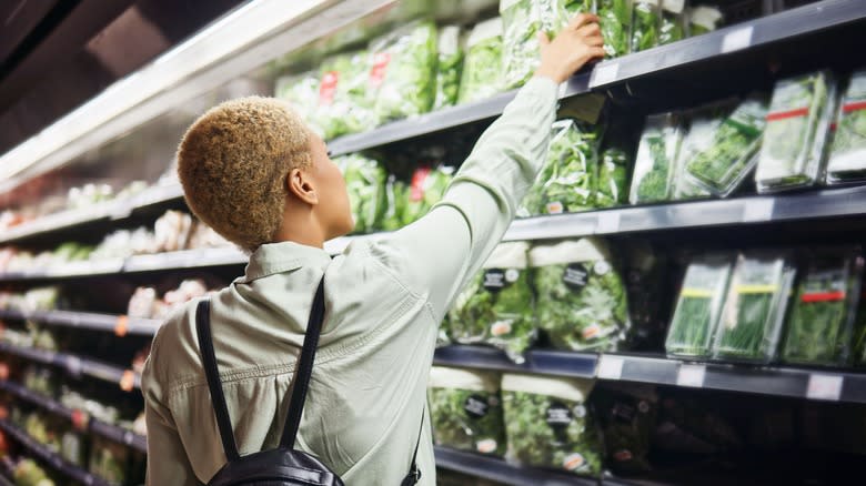 someone reaching for bagged lettuce