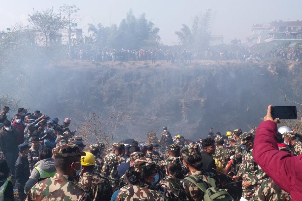Crowds gather as rescue teams work to retrieve bodies at the crash site (via Reuters)