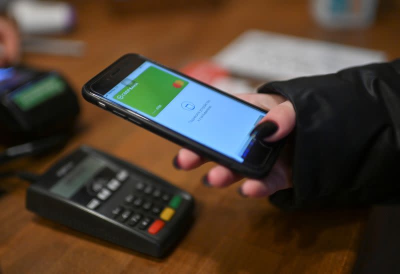 FILE PHOTO: A customer uses a mobile wallet while making a purchase with a Sberbank card at a cafe in Omsk