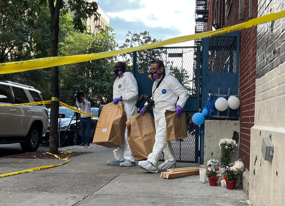 Two members of the NYPD Crime Scene Unit remove large paper bags of evidence from a day care where four children overdosed on fentanyl.