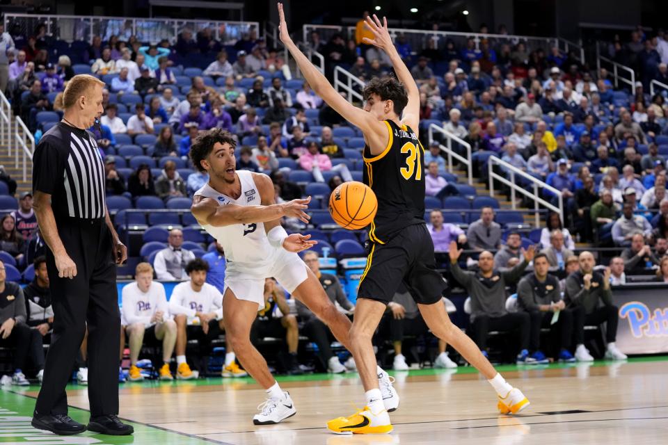 Xavier guard Colby Jones passes as Pittsburgh forward Jorge Diaz Graham defends in a second-round NCAA Tournament game March 19 at Greensboro Coliseum in Greensboro, North Carolina.