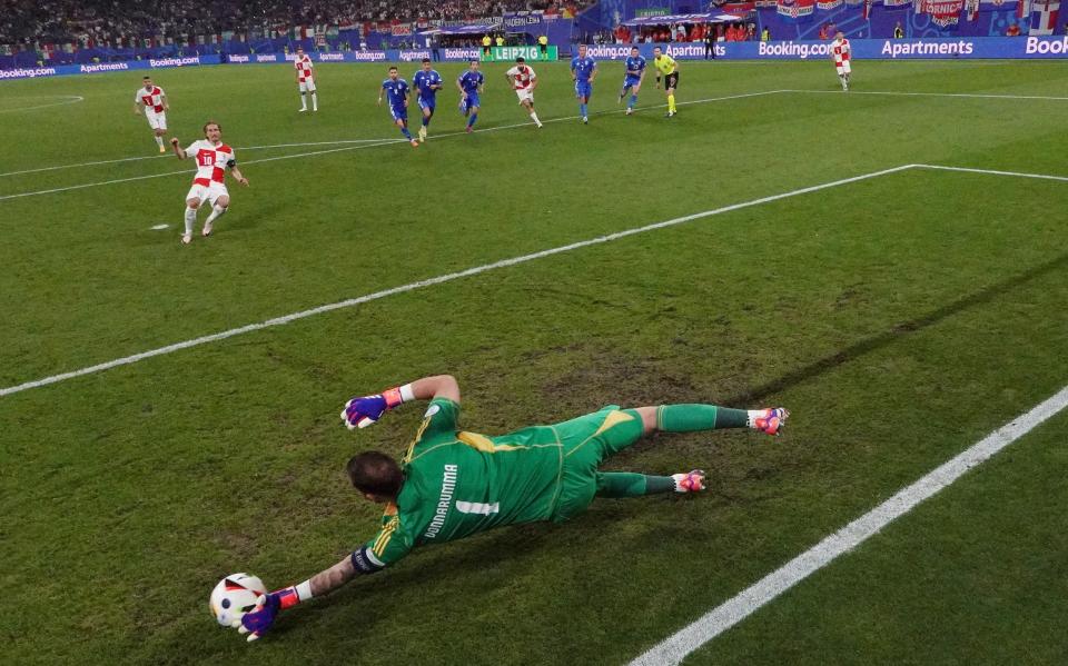 Gianluigi Donnarumma of Italy dives to save the penalty of Luka Modric