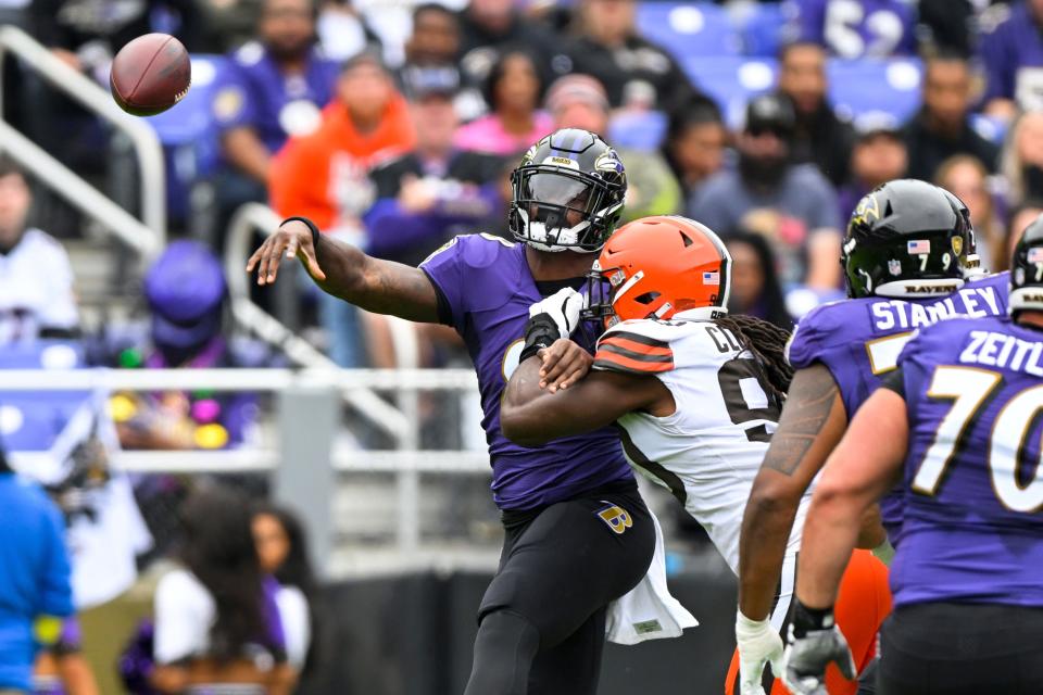 Baltimore Ravens quarterback Lamar Jackson is pressured by Cleveland Browns defensive end Jadeveon Clowney during the first half of a NFL football game, Sunday, Oct. 23, 2022, in Baltimore. (AP Photo/Terrance Williams)