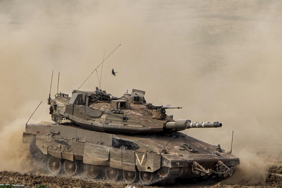 Israeli soldiers drive a tank inside Gaza Strip, as seen from southern Israel, Tuesday, Feb. 13, 2024. The army is battling Palestinian militants across Gaza in the war ignited by Hamas' Oct. 7 attack into Israel. (AP Photo/Ariel Schalit)