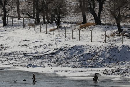 North Korean, photographed from the Chinese side of the border as they stand in the freezing Yalu River near the town of Linjiang, China, November 22, 2017. REUTERS/Damir Sagolj