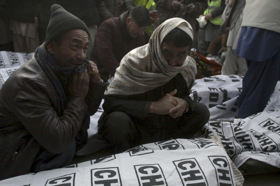 People from the Shiite Hazara community mourn around the bodies of coal mine workers who were killed by unknown gunmen near the Machh coal field, in Quetta, Pakistan, Sunday, Jan. 3, 2021. Gunmen opened fire on a group of minority Shiite Hazara coal miners after abducting them, killing 11 in southwestern Baluchistan province early Sunday, a Pakistani official said. (AP Photo/Arshad Butt)