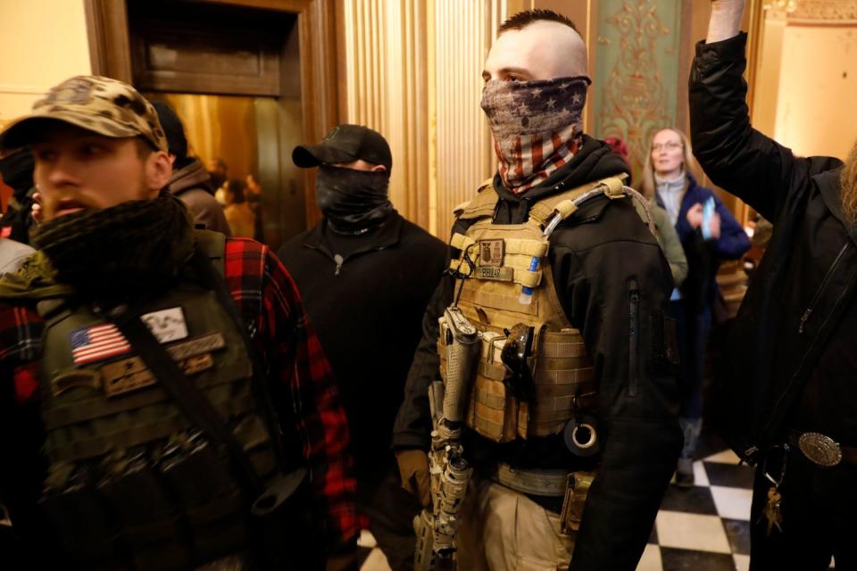 Armed protesters in the Michigan Capitol in Lansing chanted "Let us in" and "Lock her up," referring to Democratic Gov. Gretchen Whitmer.