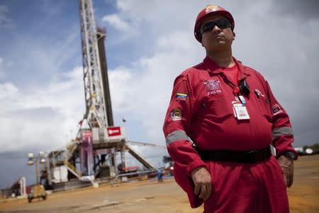 A worker stands in front of a drilling rig at an oil well operated by Venezuela's state oil company PDVSA in Morichal July 28, 2011. REUTERS/Carlos Garcia Rawlins