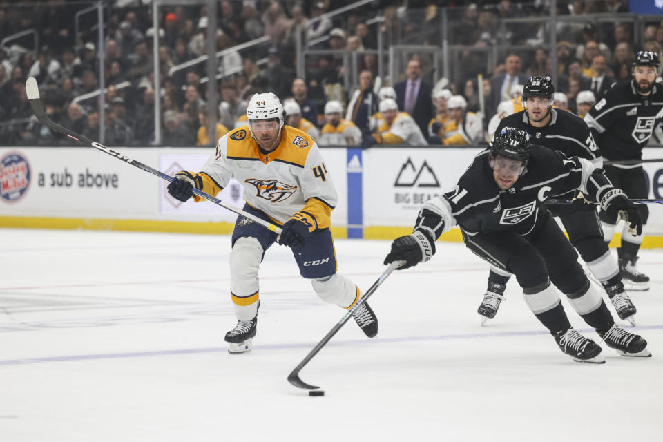 Los Angeles Kings center Anze Kopitar (11) and Nashville Predators left wing Kiefer Sherwood (44) make a play for the puck during the first period of an NHL hockey game Thursday, Feb. 22, 2024, in Los Angeles. (AP Photo/Yannick Peterhans)