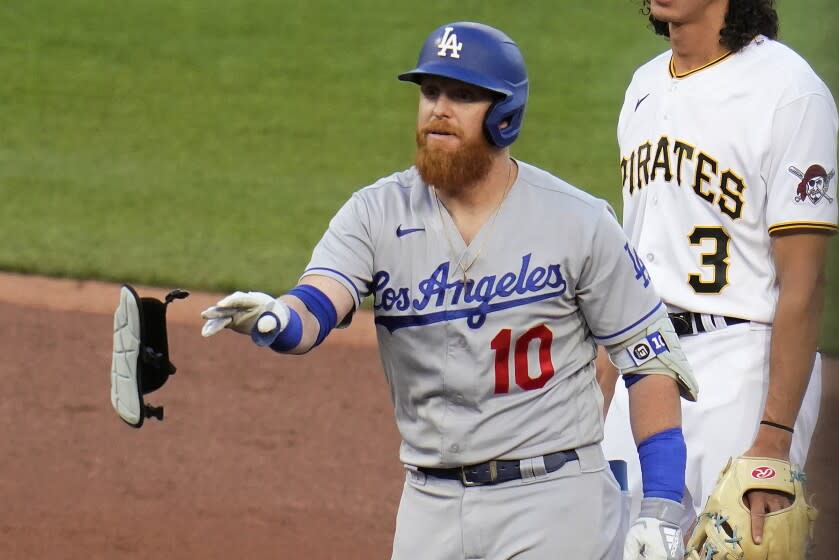 Dodgers' Justin Turner tosses his pads as he stands on second after hitting a double