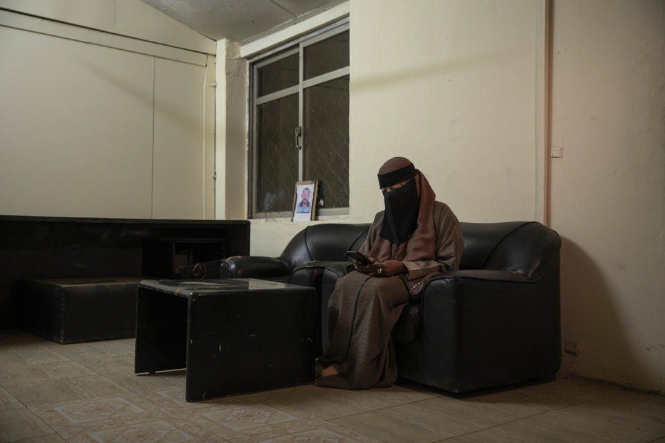 In this Jan. 11, 2020 photo, Sudanese Dr. Saadeya Seif, who lost her brother Awad Seif el-Din during last years' revolution looks at a photograph of him on her phone, after a meeting with families who lost loved ones, at the Revolutionary Martyrs Center, in Khartoum, Sudan. The young protesters who led the uprising against former President Omar al-Bashir, are now caught in the limbo of the country's fragile interim period. Generals remain the de-facto rulers of the country and have shown little willingness to hand over power to a civilian-led administration, one the demonstrators' key demands. (AP Photo/Nariman El-Mofty)