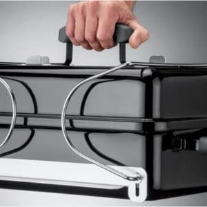 person holding handle of portable grill