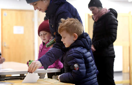 Children watch as voter casts her ballot during presidential election in Helsinki, Finland January 28, 2018. Lehtikuva/Heikki Saukkomaa/via REUTERS