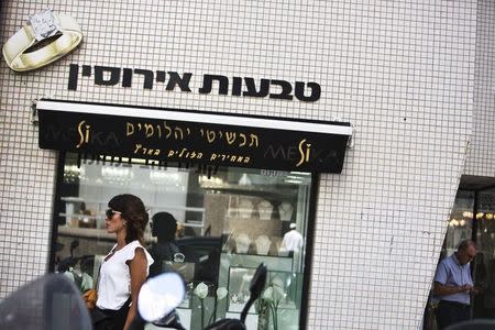 A woman walks past a diamonds and jewellery store at the Diamonds Exchange district in Ramat Gan near Tel Aviv, Israel June 23, 2015. REUTERS/Nir Elias