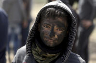 <p>A Palestinian boy poses for a photograph as he paints his face in black during a protest at the Gaza Strip’s border with Israel, Friday, April 6, 2018. (Photo: Khalil Hamra/AP) </p>