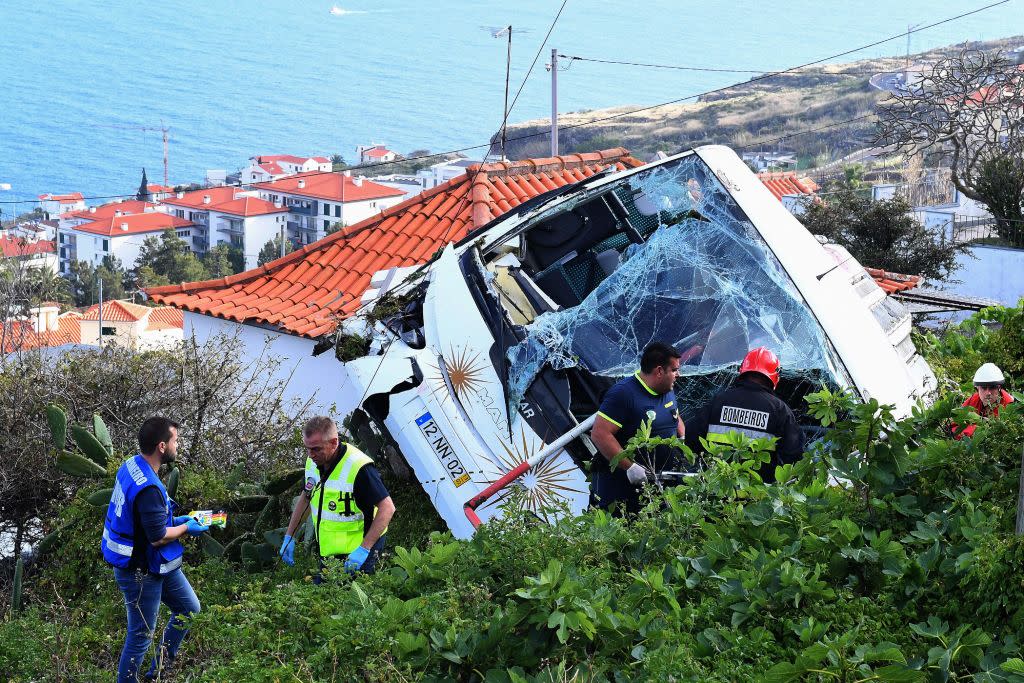 Feuerwehrleute stehen neben dem verunglückten Touristenbus in Caniço, Madeira (Getty)