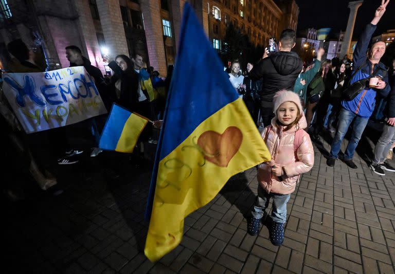 Un niño sostiene una bandera ucraniana mientras la gente se reúne en la plaza Maidan para celebrar la liberación de Kherson, en Kiev el 11 de noviembre de 2022, en medio de la invasión rusa de Ucrania.