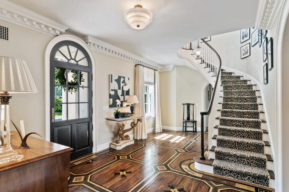 From the front entry, the home at 3338 Sunnyside Drive is filled with unique, high-end details, such as custom walnut floors and a dramatic floating staircase, as well as arched doors and windows.
