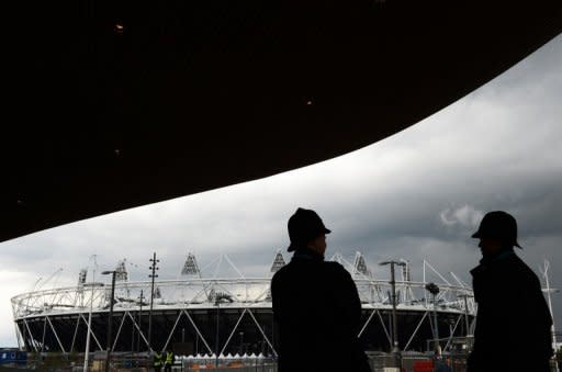 Police stand guard near the Olympic Stadium in London. While Britain's limp economy hopes for an Olympic boost, police in Newham, the deprived east London borough that is home to the stadium, have closed some 80 brothels in the 18 months to March, according to a study by a local councillor