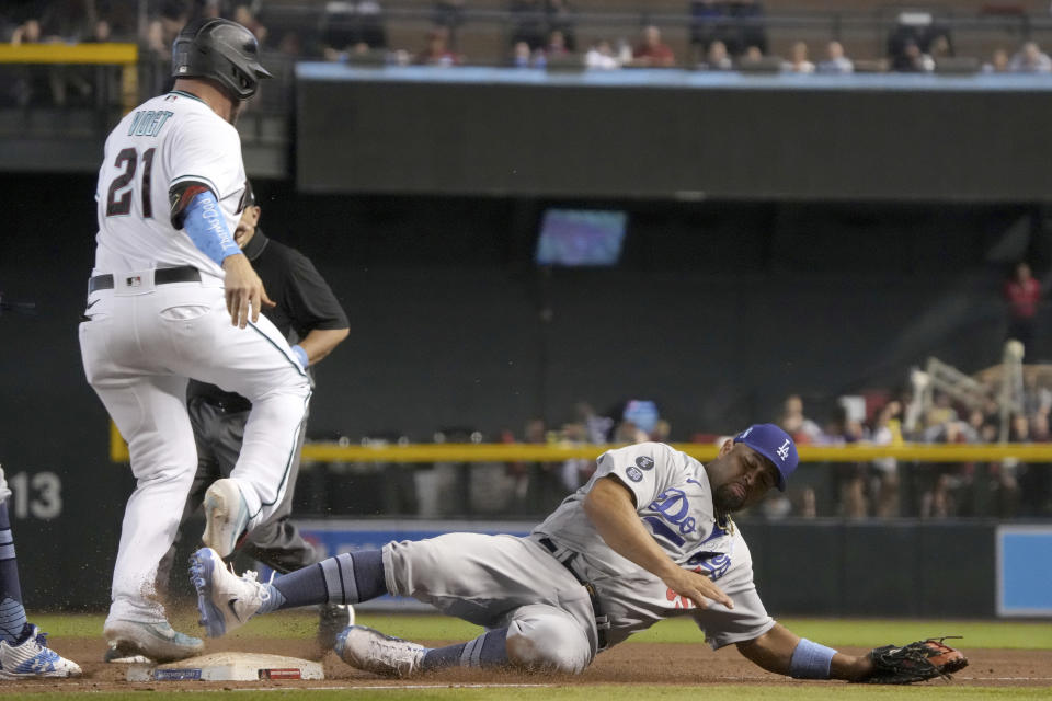 Arizona Diamondbacks' Stephen Vogt (21) hits a single by beating Los Angeles Dodgers first baseman Albert Pujols, right, to the base in the eighth inning during a baseball game, Sunday, June 20, 2021, in Phoenix. (AP Photo/Rick Scuteri)