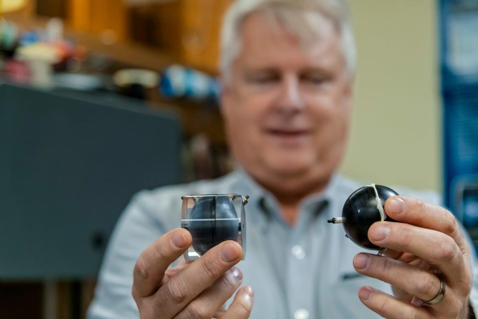 OSU physics professor Eric Benton holds up two iterations of his and Ph.D. student Tristen Lee's tissue equivalent proportional counter, a key component of their radiation detector SpaceTED.