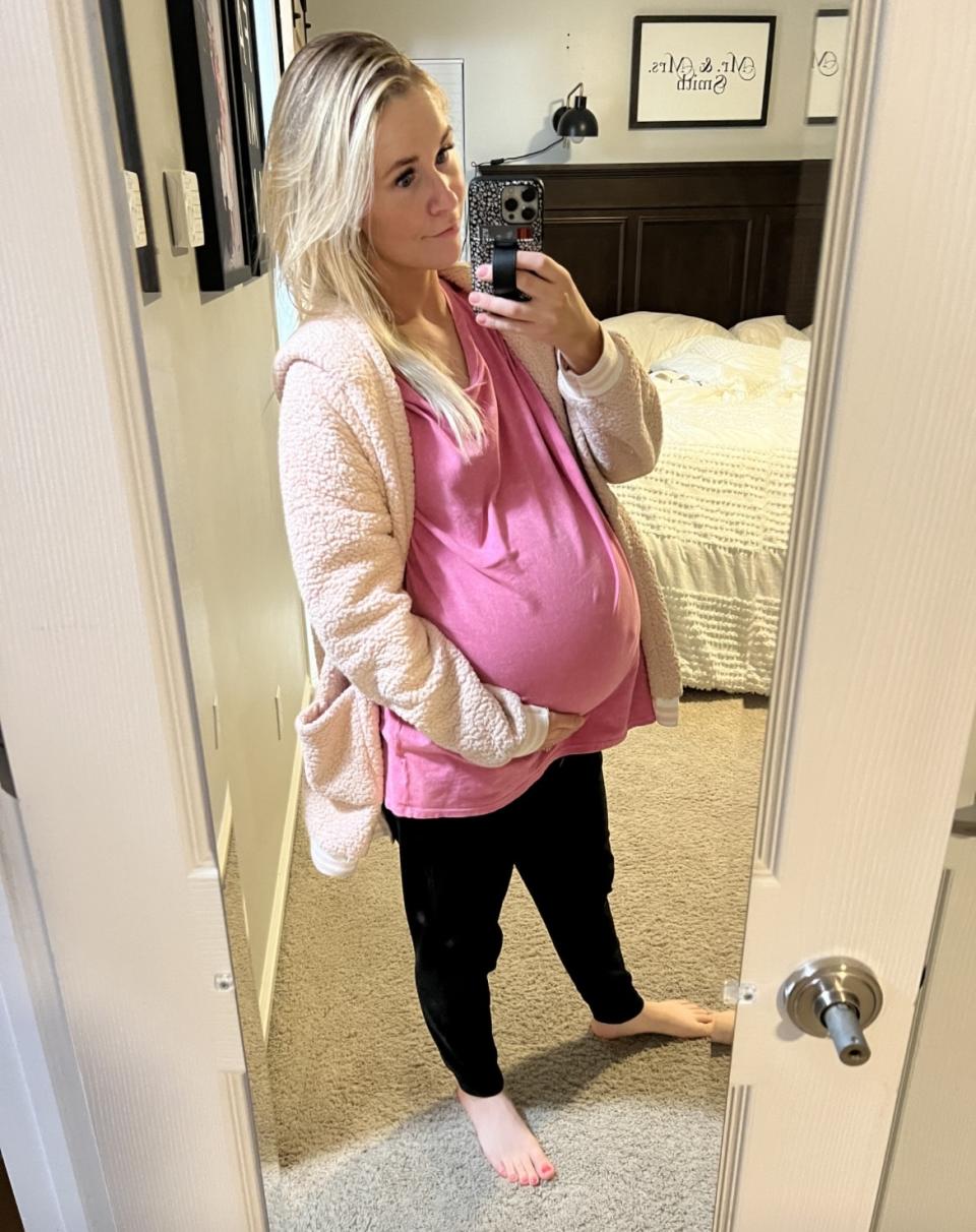 Kenya Smith takes a selfie using her closet mirror, showing a huge protuberance in her belly, as if she were carrying a pregnancy, very low.