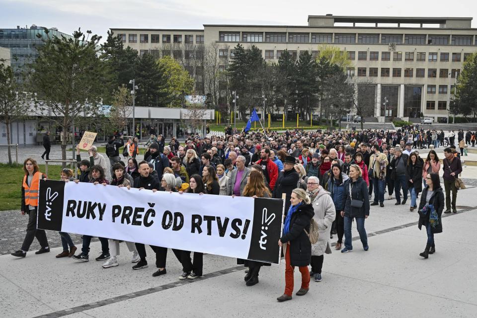 People hold a banner reading "Hands off rtvs (Slovakian public radio and tv) " as they take part in a protest organised by the Slovakian opposition parties in Bratislava, Wednesday, March. 27, 2024. People in Bratislava have formed a human chain around the building of Slovakia’s public radio and television to protest a plan by the government of populist Prime Minister Robert Fico to take over the broadcasters. The plan has been condemned President Zuzana Čaputová, opposition parties, local journalists, international media organizations, the European Commission and others have warned the changes would give the government’s full control of public broadcasting. (Pavol Zachar/TASR via AP)