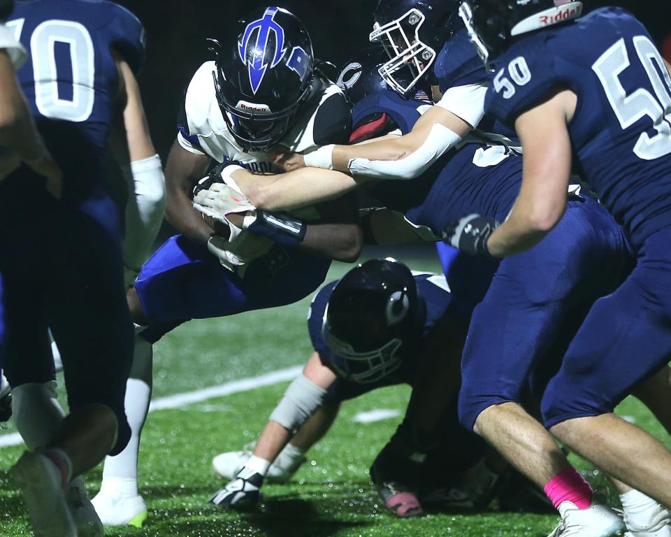 Randolph's Nathanyel Gomes Correia tries to push through the tackle of the Cohasset defense during third quarter action of their game at Cohasset Middle High School on Friday, Oct. 27, 2023. Cohasset would go on to win 43-6.