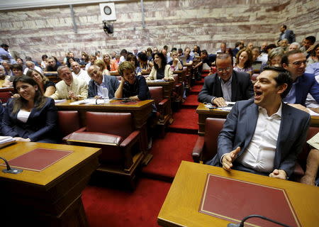 Greek Prime Minister Alexis Tsipras (R) shares a joke with Parliament Speaker Zoe Constantopoulou (L) and other lawmakers before a ruling Syriza party parliamentary group session in Athens, Greece July 15, 2015. REUTERS/Yannis Behrakis