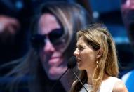 Monica Seles speaks about Justine Henin of Belgium, seen on the screen, as she is inducted into the International Tennis Hall of Fame in Newport, Rhode Island, U.S. July 16, 2016. REUTERS/Mary Schwalm