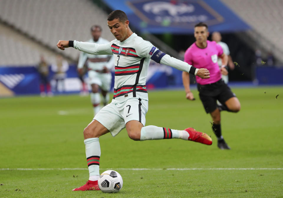 FILE - In this Sunday, Oct. 11, 2020 file photo Portugal's Cristiano Ronaldo attempts a shot at goal during the UEFA Nations League soccer match between France and Portugal at the Stade de France in Saint-Denis, north of Paris, France. The Portuguese soccer federation says Cristiano Ronaldo has tested positive for the coronavirus. The federation says Ronaldo is doing well and has no symptoms. He has been dropped from the country's Nations League match against Sweden on Wednesday. (AP Photo/Thibault Camus, File)