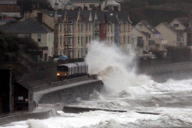 A train is battered by waves as it passes through the Dawlish train station, Devon