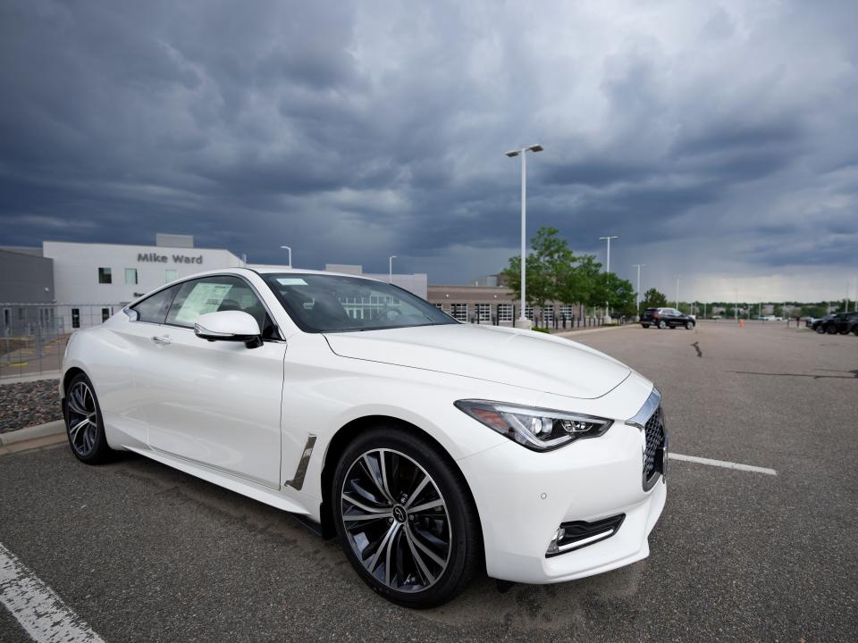 A white car against a stormy sky.