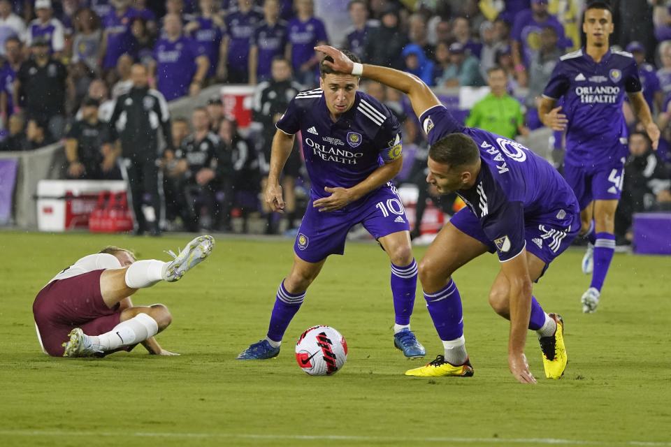 Sacramento Republic's Matt LaGrassa, left, gets tripped as he goes after the ball against Orlando City's Mauricio Pereyra (10) and Ercan Kara (9) during the first half of the U.S. Open Cup final soccer match, Wednesday, Sept. 7, 2022, in Orlando, Fla. (AP Photo/John Raoux)