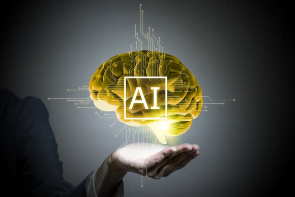 Image of human brain hovering over outstretched hand with AI superimposed over brain