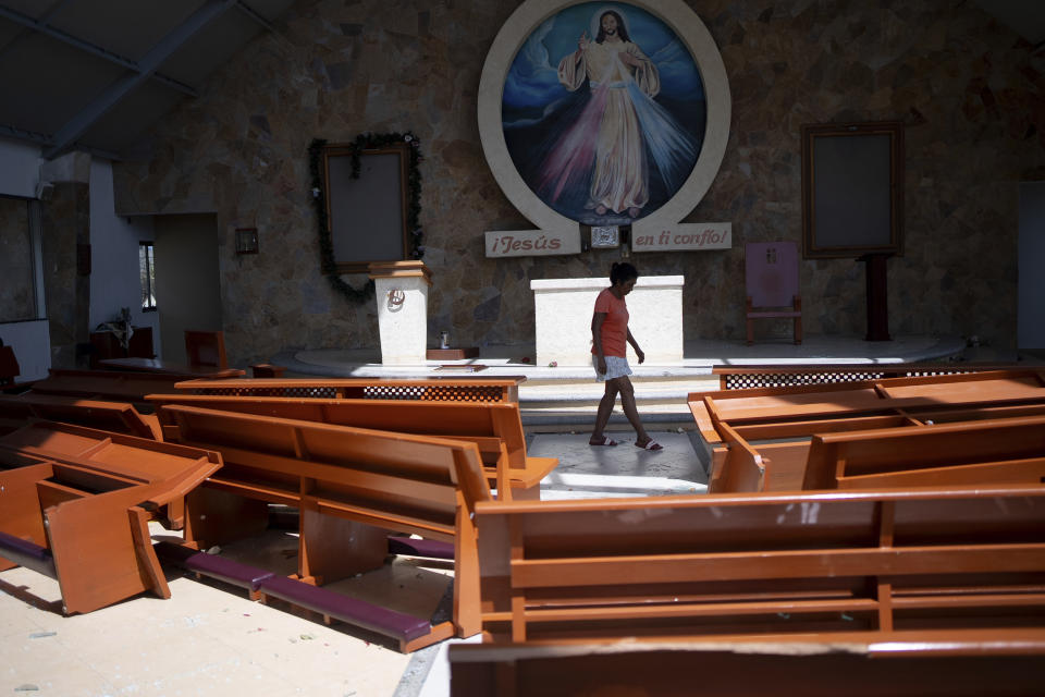 A woman walks inside a church damaged by Hurricane Otis in Acapulco, Mexico, Friday, Oct. 27, 2023. (AP Photo/Felix Marquez)