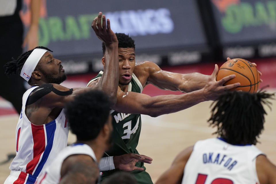 Milwaukee Bucks forward Giannis Antetokounmpo (34) is fouled by Detroit Pistons forward Jerami Grant during the first half of an NBA basketball game, Wednesday, Jan. 13, 2021, in Detroit. (AP Photo/Carlos Osorio)
