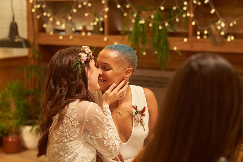 two girls at their wedding party kissing