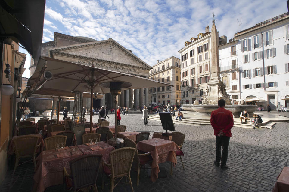 Waiters wait for customers outside a restaurant next to the Pantheon, in Rome, Thursday, March 5, 2020. Italy closed all schools and universities and barred fans from all sporting events for the next few weeks, as governments trying to curb the spread of the coronavirus around the world resorted to increasingly sweeping measures that transformed the way people work, shop, pray and amuse themselves. (AP Photo/Andrew Medichini)