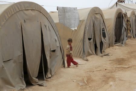 A boy walks near tents inside a refugee camp for the internally displaced persons in Jrzinaz area, southern countryside of Idlib, Syria October 13, 2015. REUTERS/Khalil Ashawi