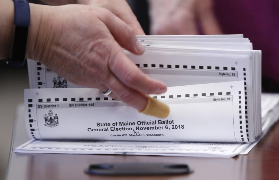 FILE - In this Nov. 12, 2018 file photo, ballots are prepared to be tabulated for Maine's Second Congressional District's House election in Augusta, Maine. Republican U.S. Rep. Bruce Poliquin and three voters sued Tuesday, Nov. 13, over Maine's new voting system, used for the first time in U.S. House and Senate elections. A lawyer for Poliquin's campaign asked the secretary of state to stop the tabulations to allow a judge to rule, but the secretary declined to stop the process.(AP Photo/Robert F. Bukaty, File)