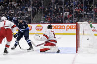 Winnipeg Jets' Pierre-Luc Dubois (80) deflects the puck past Carolina Hurricanes' goaltender Frederik Andersen (31) for a goal during the second period of an NHL game in Winnipeg, Manitoba, Tuesday, Dec. 7, 2021. (Fred Greenslade/The Canadian Press via AP)