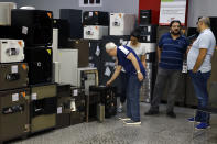 Customers checks the safes for sale at the Shehab Security shop in Beirut, Lebanon, Wednesday, Nov. 20, 2019. Lebanon’s worsening financial crisis has thrown businesses and households into disarray. Banks are severely limiting withdrawals of hard currency, and Lebanese say they don’t know how they’ll pay everything from tuitions to insurance and loans all made in dollars. Politicians are paralyzed, struggling to form a new government in the face of tens of thousands of protesters in the streets for the past month demanding the entire leadership go. (AP Photo/Bilal Hussein)